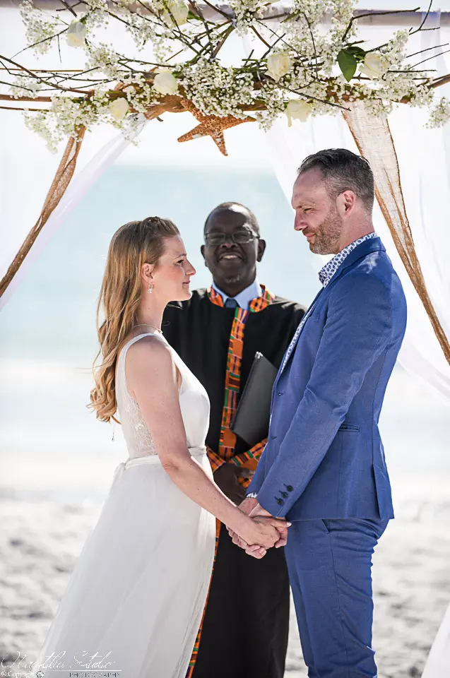 Oficiante de boda en Florida, recién casados ​​tomados de la mano durante la ceremonia