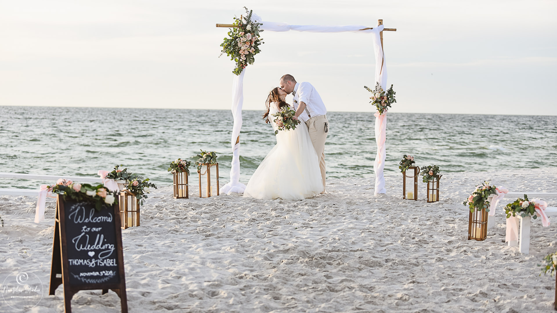 Boda elopement Naples Florida, foto de la novia y el novio besándose bajo el arco de la boda