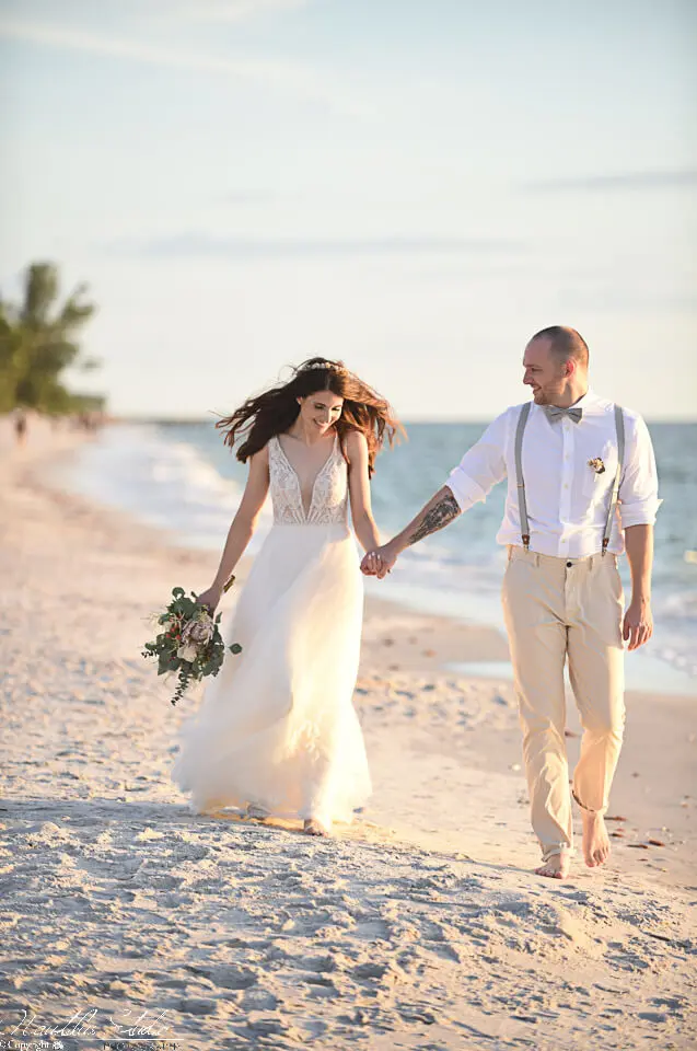 Naples Florida Strandhochzeit, Hochzeitspaar Hand in Hand am Strand