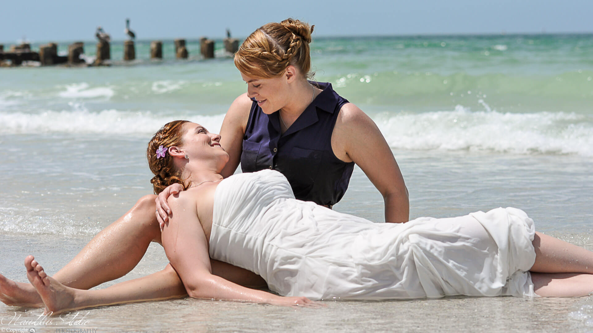 Boda del mismo sexo, boda del mismo sexo, dos mujeres yacen en la orilla del mar