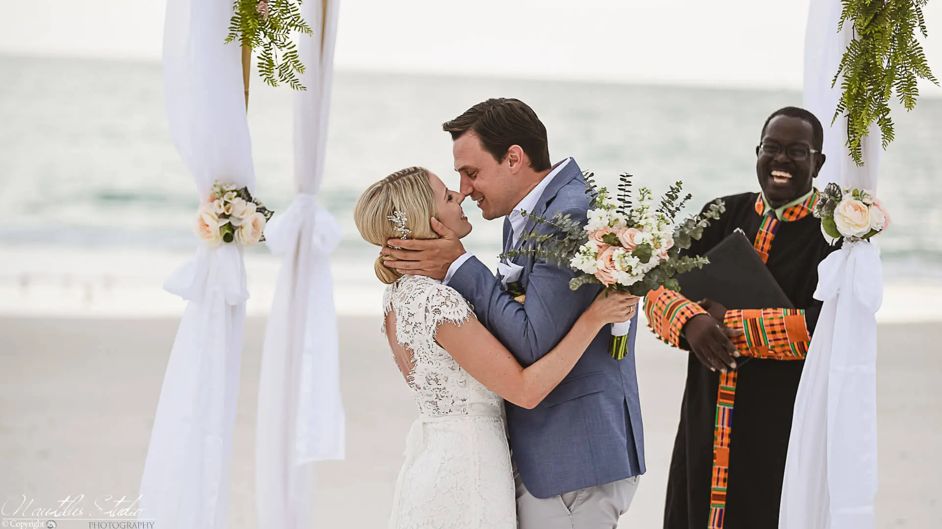 Oficial de bodas en Florida, los recién casados ​​se besan bajo el arco de la boda