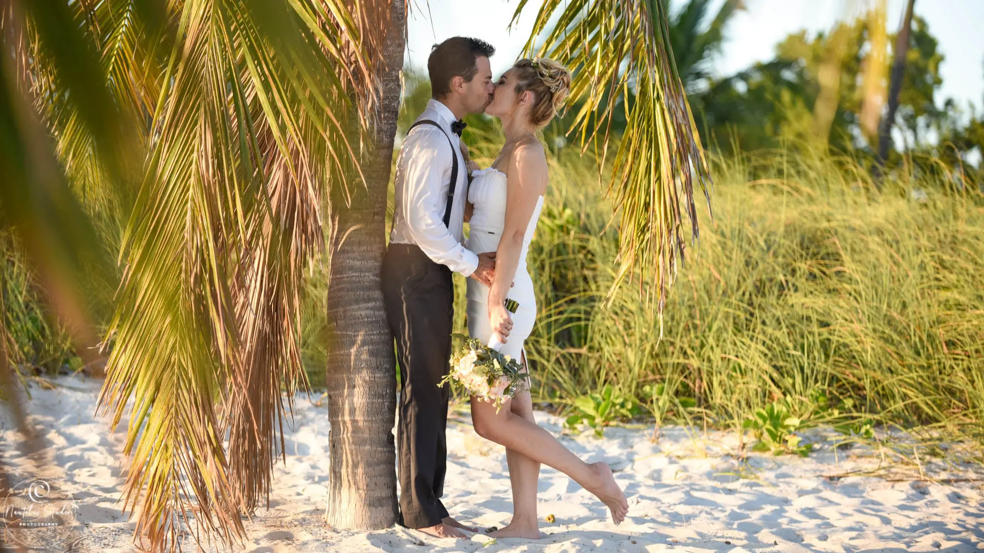 Hochzeit für zwei in Florida, Foto von Brautpaar das sich unter Palmen küsst