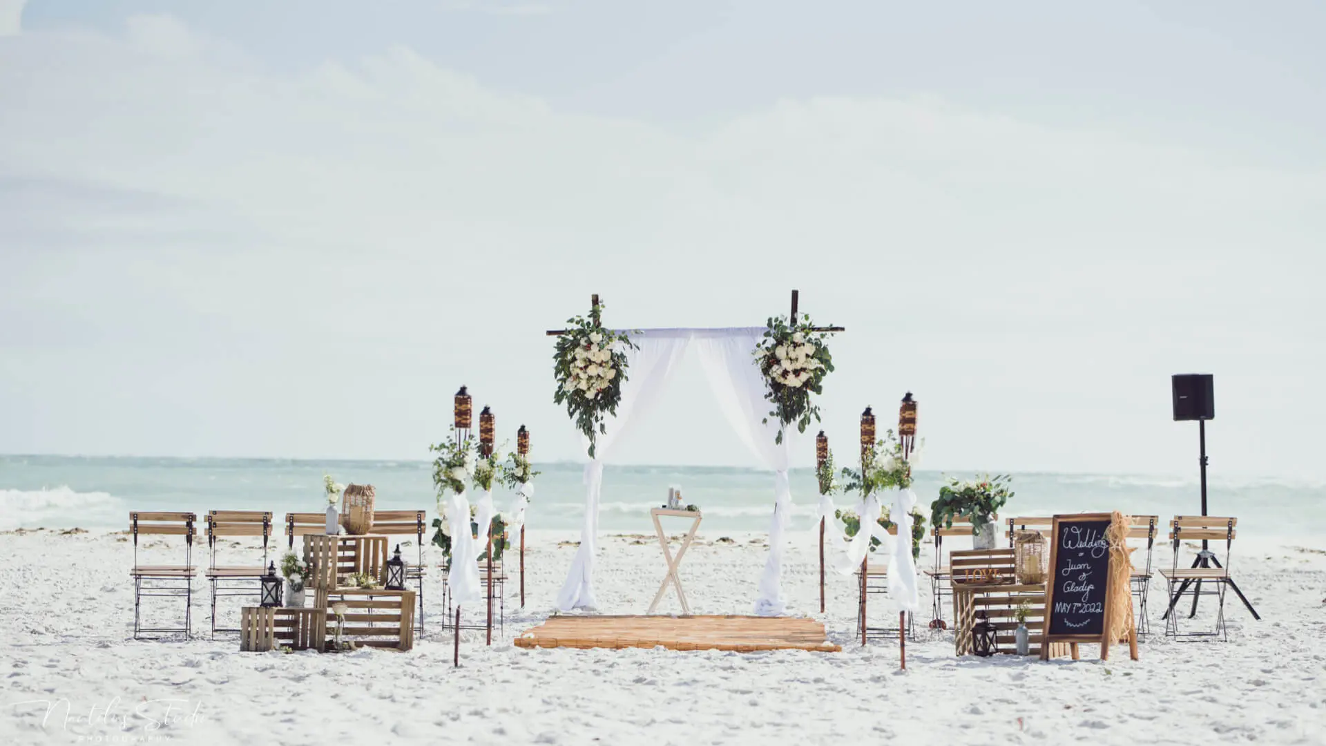 Estilo de vida y decoración vintage de bodas en la playa con flores frescas y sillas de campo francesas